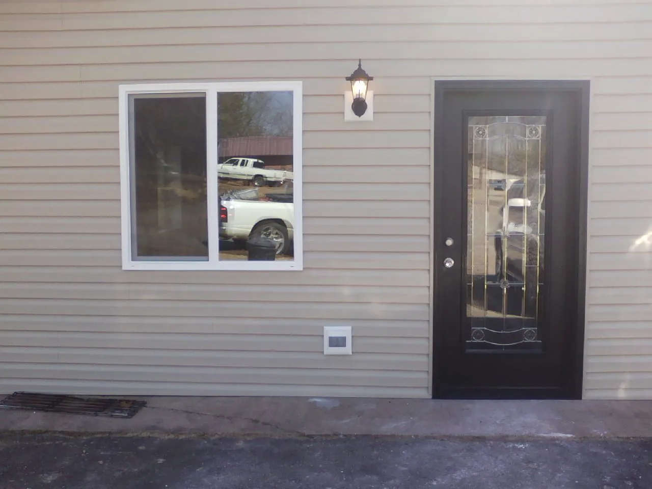 New siding, window and entry door on the side of an addition in Homer City